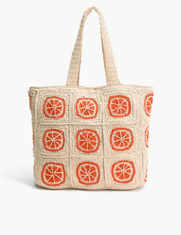 A Vibrantly colored orange crochet beach tote with metallic button closure and double shoulder straps.